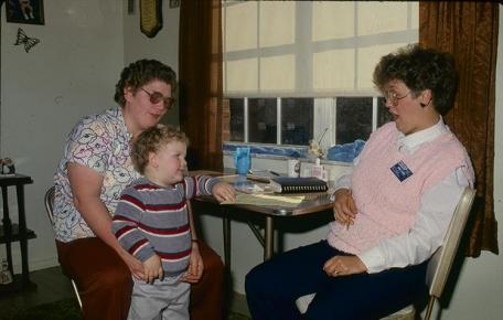 An archive photo of former Boyd County EFNEP  assistant Donna Powers working with a family.