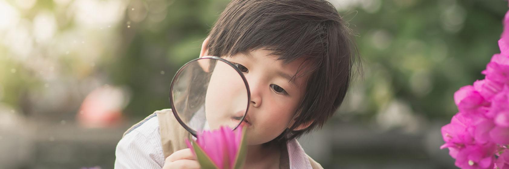 background image. Child with magnifying glass
