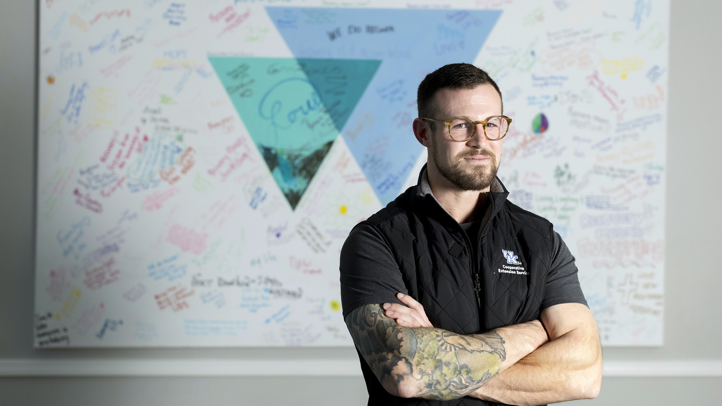 Alex Elswick stands before the wall of hope at the Voices of Hope facility. Photo credit: Sabrina Hounshell