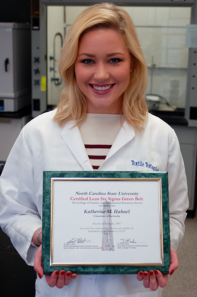 Katie Hahnel holding her Six Sigma Green Belt Certificate