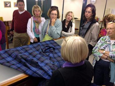 Examining plaid textiles at the House of Edgar warehouse